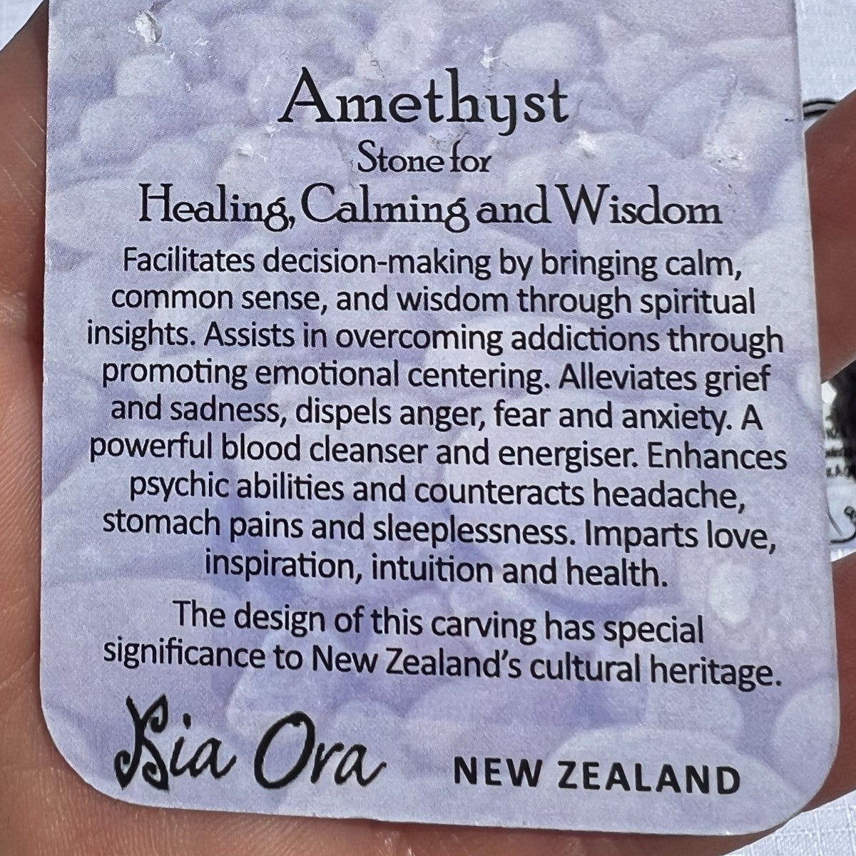 Card with information about amethyst stone, featuring text on a textured background.