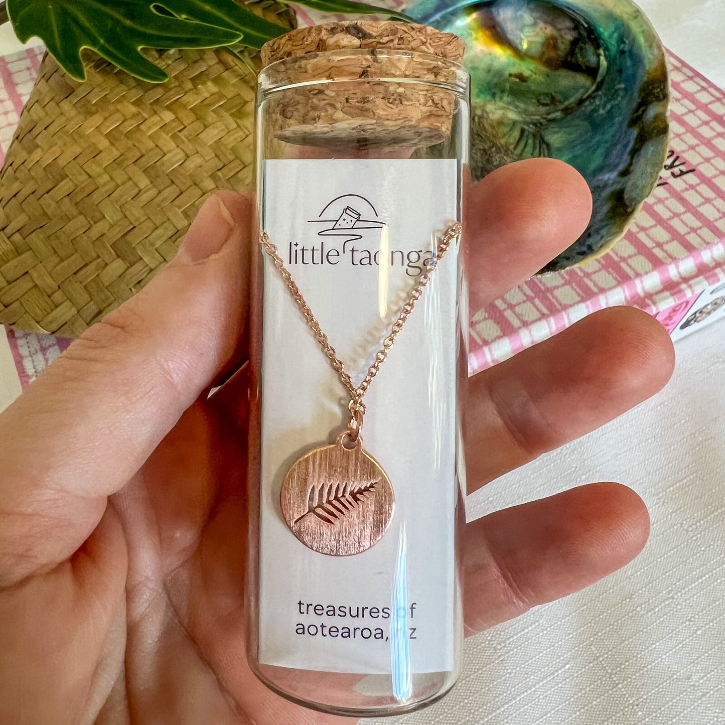 Rose gold silver fern necklace by Little Taonga in glass gift bottle – NZ symbol pendant representing strength and pride