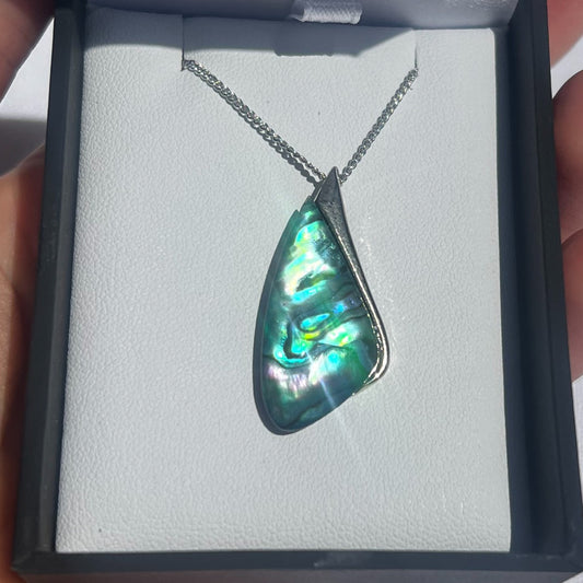 Necklace with a green abalone shell pendant in a box