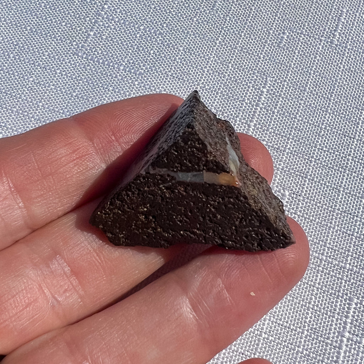 Queensland boulder opal rough specimen with dark brown ironstone, an angular peaked shape and a pale seam, SKU 1448
