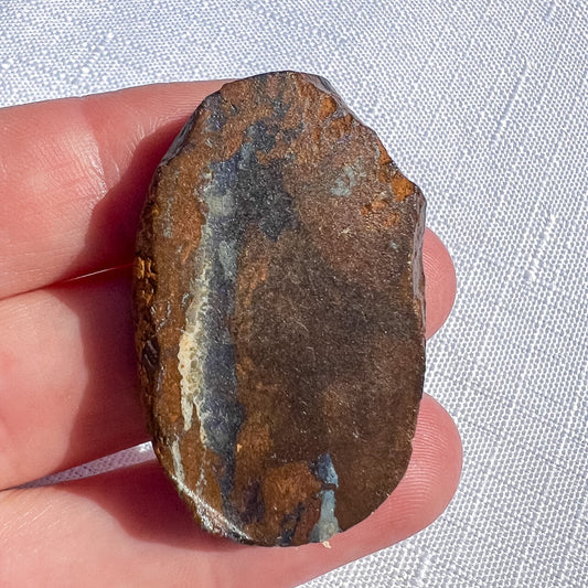 Queensland boulder opal rough specimen with brown tones and a pale-edged grey-blue band, measuring 38 × 26 × 8 mm