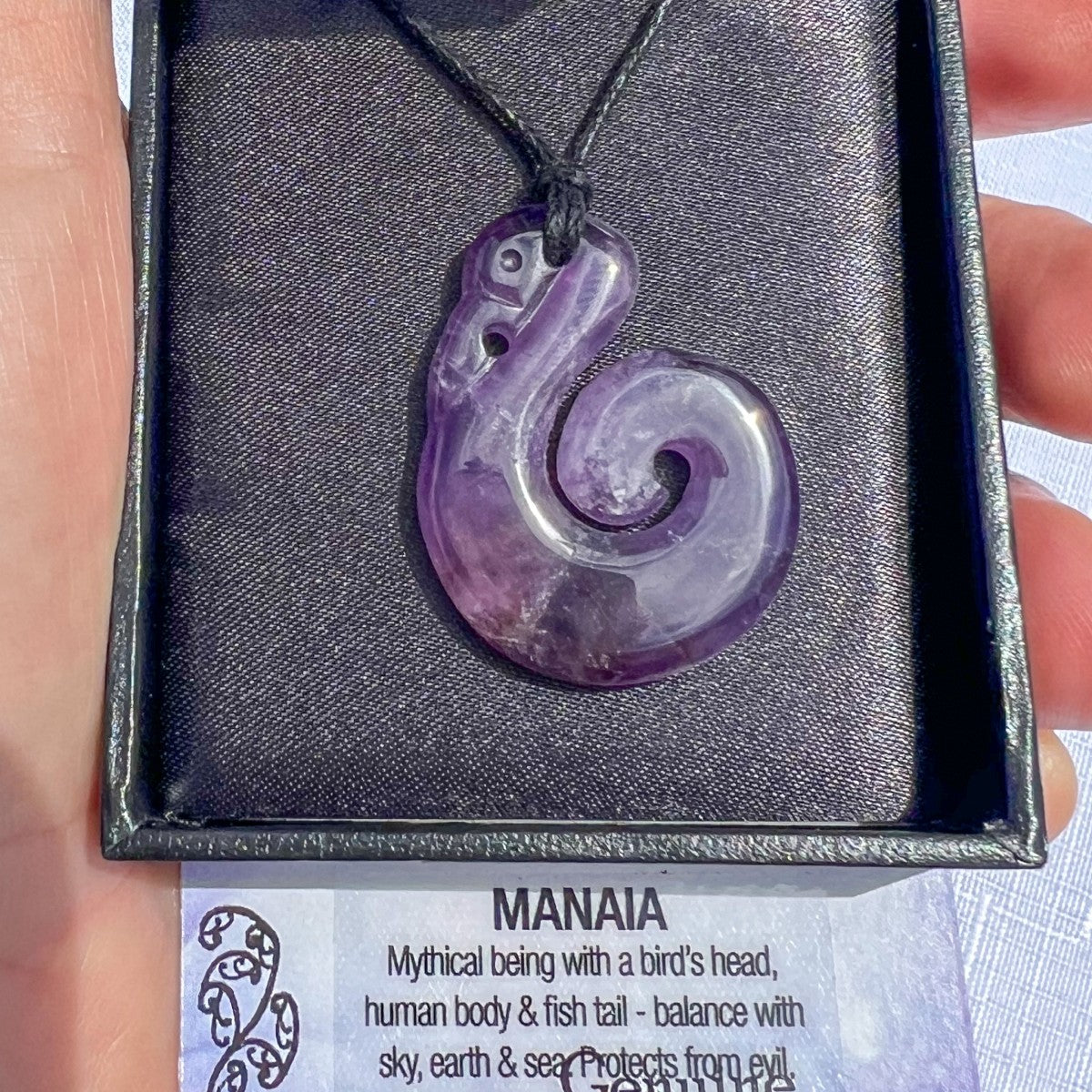 Amethyst Manaia pendant necklace on a black cord, symbolising spiritual protection and balance between sky, earth, and sea — hand-carved in New Zealand.