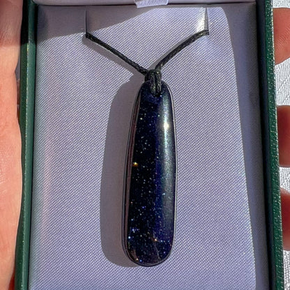 Black stone pendant on a cord in a box