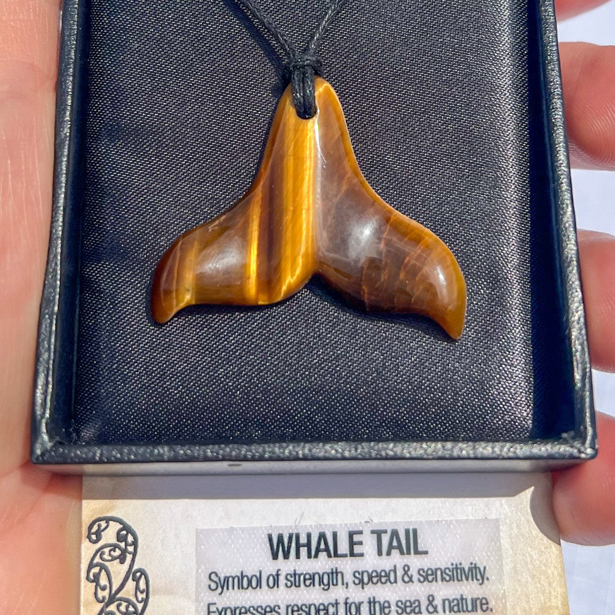 Tiger eye Whale Tail pendant necklace on a black cord, symbolising strength, protection, and safe passage — hand-carved in New Zealand.