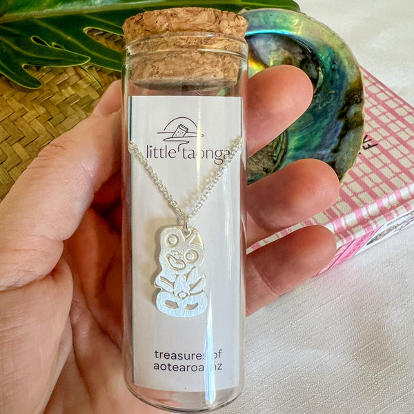 Sterling silver hei tiki necklace by Little Taonga in glass gift bottle – good luck and protection pendant from New Zealand